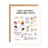 Greeting card with colorful hand-drawn illustrations and handwritten text listing positive things about winter, including twinkly lights, hot cocoa, oversized sweaters, and campfires on a white background.