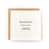 Care Instructions Letterpress Card reading Be gentle with yourself with brown kraft envelope on white background