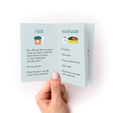 A hand holds open the "How to Support Someone Zine," displaying two pages with illustrated lists of supportive actions. The left page shows food-related help suggestions, while the right page lists housework assistance ideas, all presented on a soft mint-colored background.