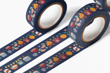 Cozy Winter Washi Tape featuring navy blue decorative tape with whimsical winter illustrations including hot chocolate mugs, oranges, warm socks, snowflakes, and stars in coral and orange tones, displayed in three parallel rows showing the repeating pattern design