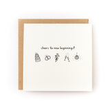 Folded letterpress card with celebratory icons and text reading cheers to new beginnings on white cardstock