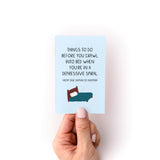 Small light blue zine titled "Things to Do When You're in a Depressive Spiral" featuring a minimalist illustration of a bed. The 4.25" x 2.75" self-help guide is shown being held against a white background, displaying its simple, comforting design and text layout.