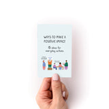 Hand holding a small zine titled Ways to Make a Positive Impact with simple illustrations and text on a white background