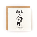 Yay You're Dads Letterpress Card with two dads holding a baby illustration, printed on soft white cardstock.