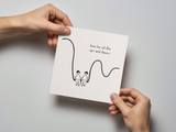 Square white greeting card held by two hands, featuring a simple black line drawing of two people sitting close together on a curved line with handwritten text saying "here for all the ups and downs.