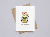 Minimalist greeting card showcasing a hand-drawn lucky cat with orange and black spots, wearing a green collar, holding a gold coin, and the phrase "wishing you good fortune" below, paired with a brown kraft envelope.