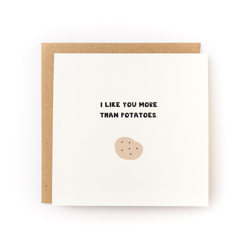 I Like You More Than Potatoes Letterpress Card featuring minimalist design with black text and simple potato illustration on cream paper, paired with kraft envelope. Square format greeting card with playful declaration of affection comparing love to beloved potatoes.