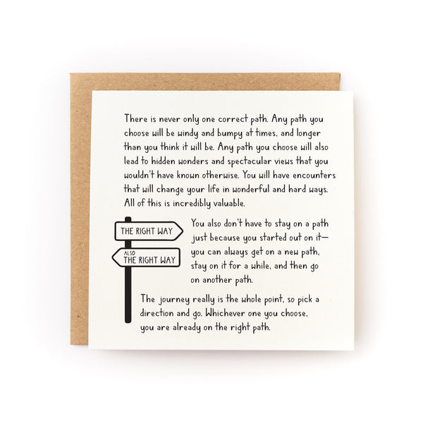 Square letterpress card "Whichever Path You Choose (It's The Right One)" featuring black text with an illustrated directional sign post showing "THE RIGHT WAY" arrows pointing in opposite directions, accompanied by a kraft brown envelope. The card contains inspirational message about life's journey printed on soft white cardstock.