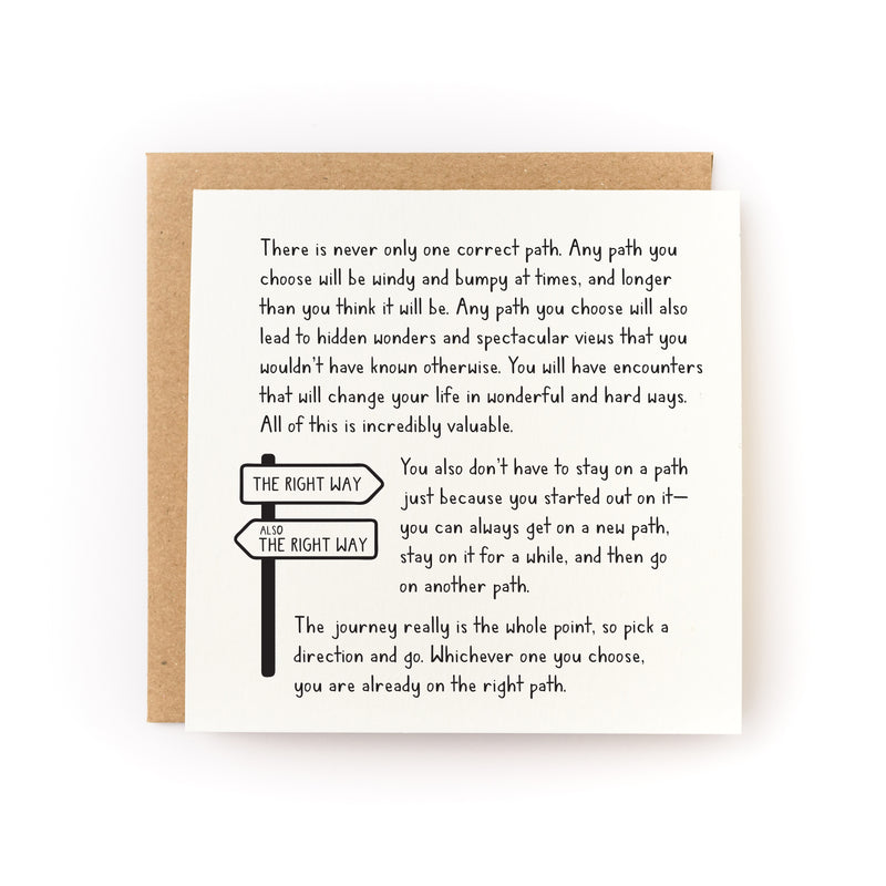 Square letterpress card "Whichever Path You Choose (It's The Right One)" featuring black text with an illustrated directional sign post showing "THE RIGHT WAY" arrows pointing in opposite directions, accompanied by a kraft brown envelope. The card contains inspirational message about life's journey printed on soft white cardstock.
