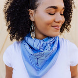 Sky blue cotton bandana with fun screen printed design in navy ink. The bandana artwork includes an original handwritten poem and illustrations of people and flowers.