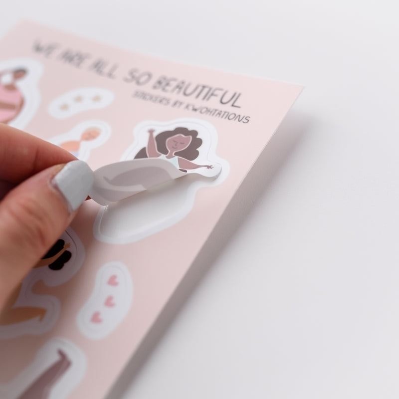 Photo of a hand holding a cute vinyl sticker.  The sticker has an illustration of  a woman dancing.