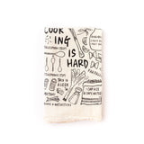 Folded up Cooking is Hard Cotton Flour Sack tea towel with cute illustrations on how to cook rice and what a leek is.