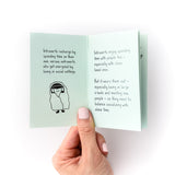 Hand holding open small mint book that says how introverts recharge with an illustration of a person sleeping